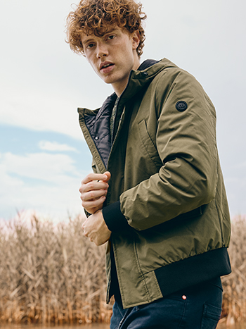 Ragazzo con giacca verde militare e jeans