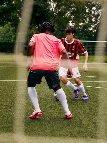 Due ragazzi che giocano a calcio con abbigliamento club