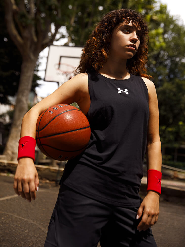 Ragazza col pallone da basket vestita Under Armour