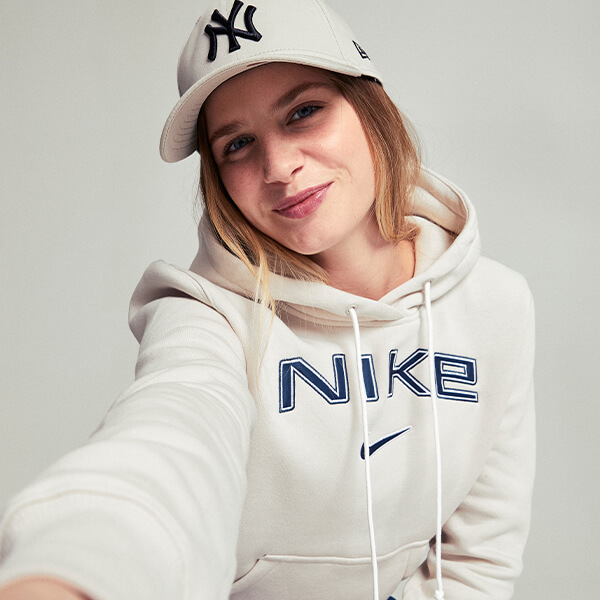 Ragazza che indossa felpa nike bianca e cappellino NY